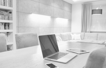 Black and white photo of  gadgets placed on table at home