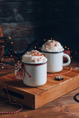 Cozy Christmas composition.Two mug with hot drinks, chocolate with whipped cream and cinnamon stick...