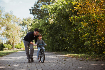 Naklejka premium Father Learning his son to ride a bicycle