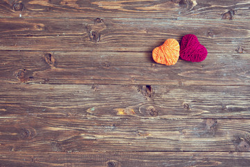 Two heart shape of yarn on vintage wooden background