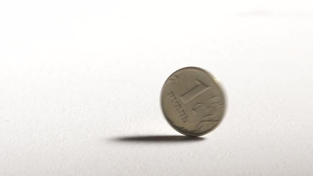 1 Russian ruble coin spinning and dropping on desk. One rouble currency of Russian Federation.