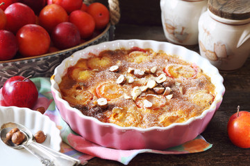 Autumn dessert. Red plums clafoutis, hazelnut and icing sugar dressing, french cuisine