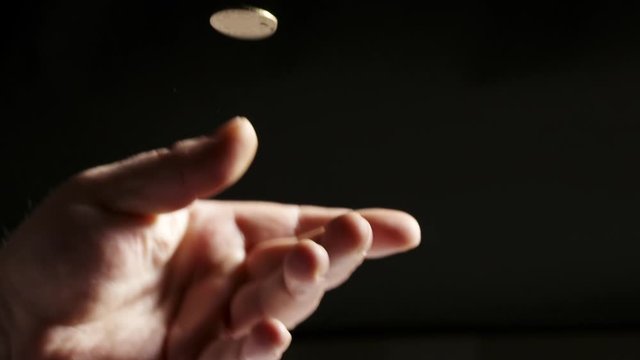 Hand tossing a coin. Throwing 1 Ukrainian hryvnia coin in the air close-up.