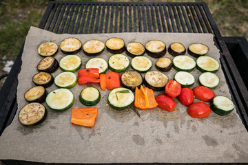 Sliced Vegetables Are Grilled. Paprika, Aubergines And Zucchini Lie On Parchment Over Charcoal