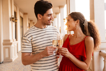 Image of happy caucasian couple hugging and drinking champagne