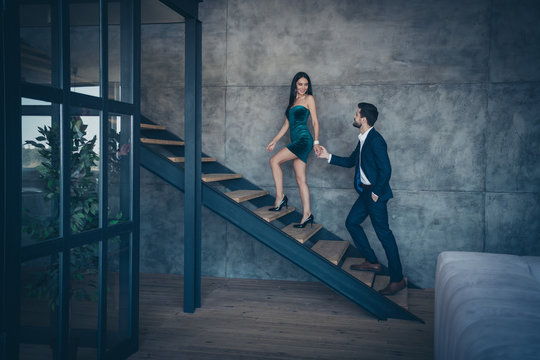 Full length profile photo of tender stylish trendy couple guy lady erotic desire climbing up second floor holding hands new house excursion wear formalwear suit short dress loft industrial indoors