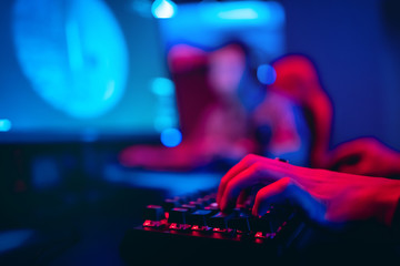 Blurred background computer, keyboard, blue and red lights. Concept eSports arena for gamer playing...