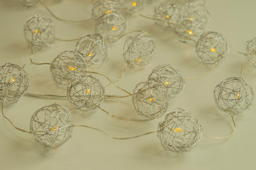 Fascinating decoration for Christmas and New Year. Metallic spherical lights on the natural white background. Trendy concept, design decision