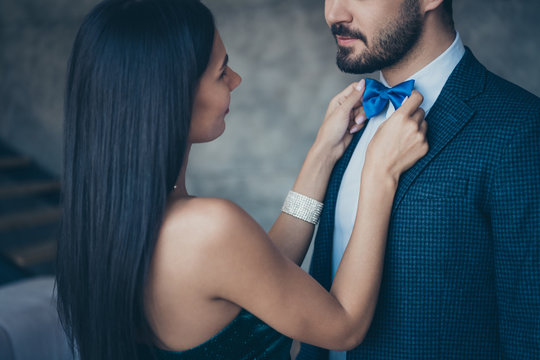 Cropped photo of two chic people couple guy looking lady who fixing taking care of blue stylish bow tie best pair at birthday party wear classy formalwear suit dress indoors