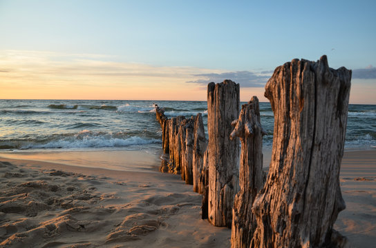 Wooden breakwater during sunset over the Baltic Sea, Unieście, Poland.