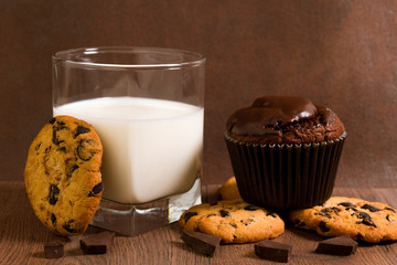 Glass of milk and chocolate muffin. Chocolate Chip Cookies. Slices of chocolate. Evening dessert