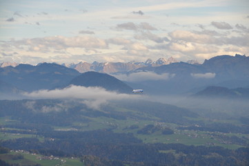 a zeppelin airship flying over the Alps seen from the Pfänder, Voralberg, Austria