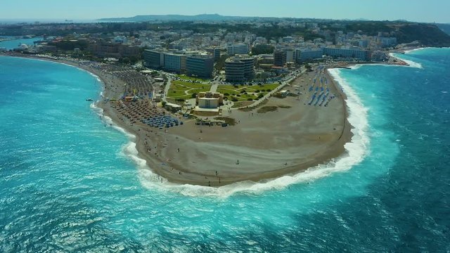 flying on a drone over a beautiful beach with turquoise water and shoreline with hotels of Rhodes Greece Europe. Ellie beach