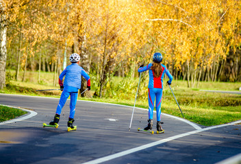 Boy and girl on skier rides on the track 