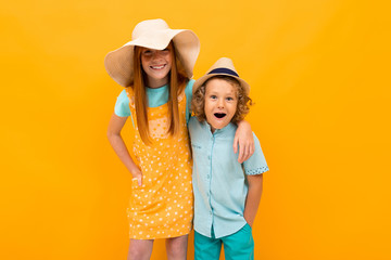 funny brother with sister on orange wall background