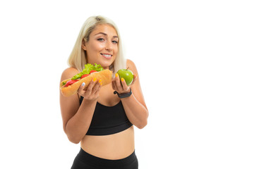 blonde in sports top with a sandwich in hand on a white background