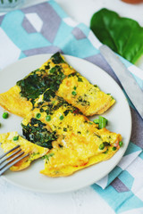 healthy breakfast, egg frittata with spinach, dill, green peas on a light background