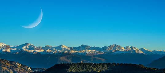 Obraz premium Panorama landscape view of Alps in Switzerland from the top of Rigi Kulm on twilight time and Panorama landscape view of Alps in Switzerland on twilight time and C-shaped of the moon.