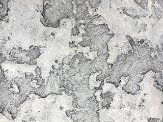 Old gray wall covered with shabby uneven plaster. Texture of vintage silver stone surface, closeup.
