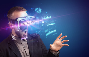 Fototapeta na wymiar Businessman looking through Virtual Reality glasses with PARTNERSHIP inscription, new business concept