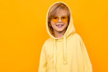 schoolboy in a yellow hoodie on a yellow background