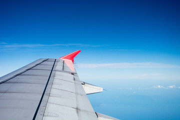 Looking through window aircraft during flight in wing with a nice blue sky.