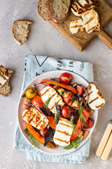 Tomato, baked pepper and onion salad with grilled haloumi cheese (halloumi). Keto diet, healthy food.