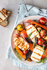 Tomato, baked pepper and onion salad with grilled haloumi cheese (halloumi). Keto diet, healthy food.