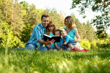 happy family reading the Bible in nature