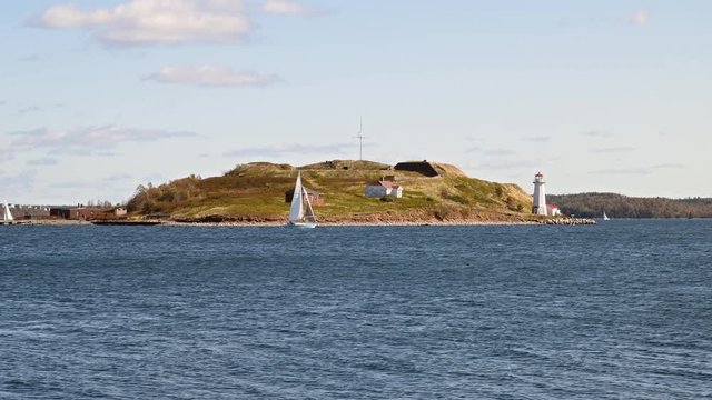 Boats sail by Georges Island in Halifax, Nova Scotia, Canada