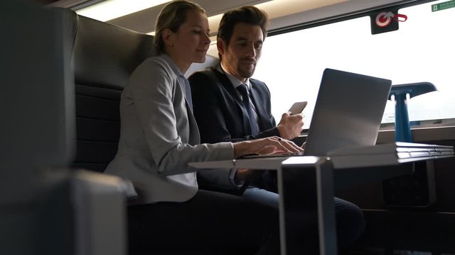 two colleagues working on a train