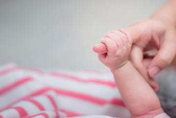 Hand the sleeping baby in the hand of mother close-up