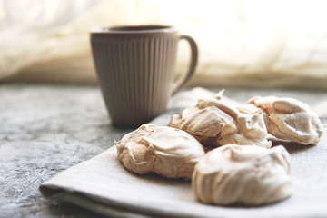 Homemade white meringue  cookies on linen textile. Selective focus.  Morning light. Beautiful...