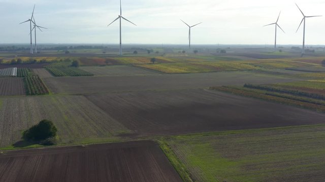 Aerial view of wind turbines beside vineyards in Germany. On a sunny day in Autumn, fall. Descending beside the turbines.