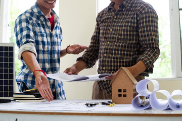 Team Engineers are writing solar panel for home construction designs to bring them to prospective customers.concept