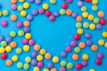 sweets, confectionery and valentine's day concept - bright multicolored candy drops in shape of...