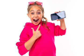 naughty girl in a pink hoodie on a white isolated background gestures to a smartphone