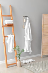 Clean bathrobe hanging on wall in room