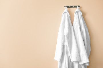 Clean bathrobes hanging on wall in room