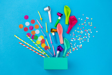 celebration and decoration concept - gift box and birthday party props on blue background