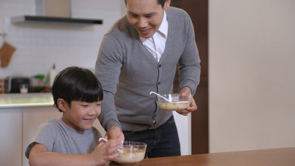 Holiday concept. Father and son are eating food together happily. 4k Resolution.