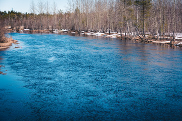 Fototapeta na wymiar Spring river in the forest area after the ice drift.
