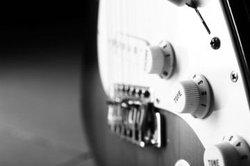 Black and white photo of modern bass guitar, closeup