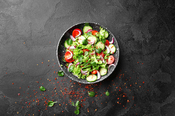 Plate with fresh vegetable salad on dark background