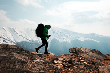 Amazing landscape with snowy mountains range and backpacker with backpack on a foreground