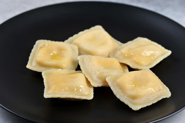 Ravioli on a black plate. Close-up. Macro shot.
