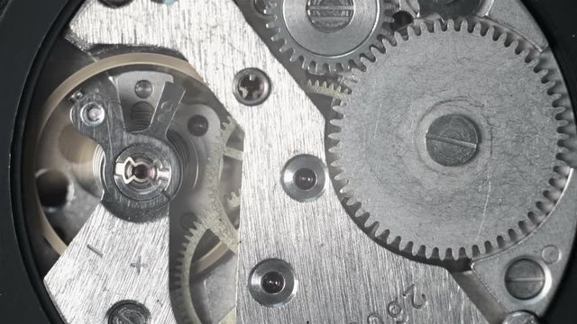 4K Watch mechanism close-up view with little gears rotating and spring unwinding