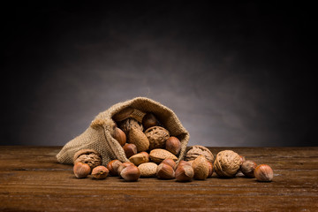 mix of dried fruits in jute gab on wooden table