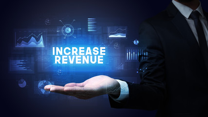 Hand of Businessman holding INCREASE REVENUE inscription, business success concept