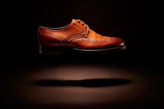 flying brown leather shoe